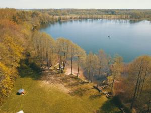 an aerial view of a lake with a boat in it at Palapinė medyje in Barkellai