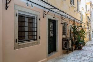 a building with a black door on a street at Townhall Studio in Corfu Town