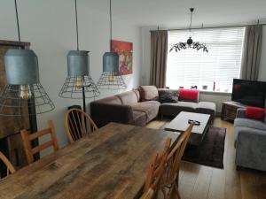 Katwijk aan ZeeにあるWoning Emmastraatのリビングルーム(テーブル、ソファ付)