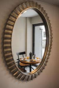 a mirror reflecting a table and a chair in a room at Nantin Hotel Ioannina in Ioannina