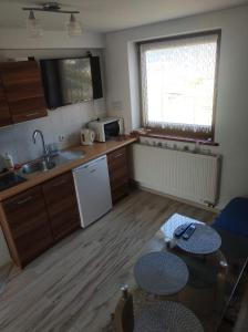 uma pequena cozinha com um lavatório e uma mesa em Wypoczynek Pod Trzynastką em Krościenko