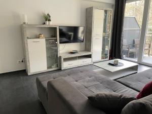 a living room with a couch and a flat screen tv at Appartement im Herzen von Leimen in Leimen