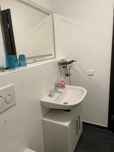 a white bathroom with a sink and a mirror at Appartement im Herzen von Leimen in Leimen +4 photos