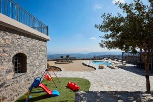 un patio con parque infantil y piscina en Irma Villa, a Secluded Sanctuary, By ThinkVilla en Krousón