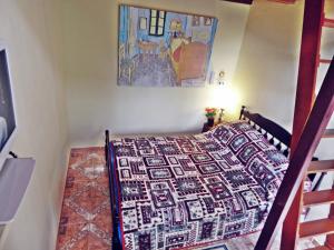 a bedroom with a bed with a quilt on it at Chalés Van Gogh in Teresópolis