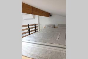 a white bed in a room with at Studio Moderne in Saint-Symphorien-dʼOzon