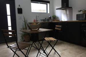 a kitchen with two chairs and a table and a counter at Studio Moderne in Saint-Symphorien-dʼOzon
