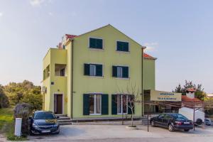 a yellow house with cars parked in front of it at Villa Katarina in Sreser