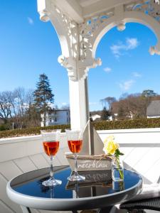 Dois copos de vinho numa mesa no alpendre. em Hotel meerblau em Ostseebad Sellin