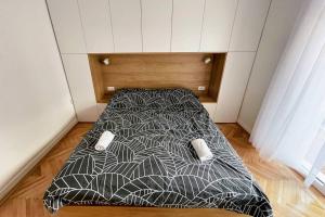 uma cama num pequeno quarto com uma roupa de cama espectrosespectrosspectos em MILLENNIUM bridge cozy apartment TOP location em Podgorica