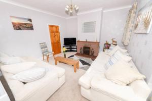 a living room with two white couches and a fireplace at The Bungalow at Seaway's, Sleeps 11 + in Great Driffield