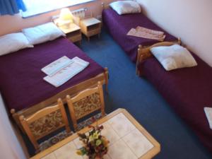 オレツコにあるHotelik Centrumのベッド2台とテーブルが備わるホテルルームです。