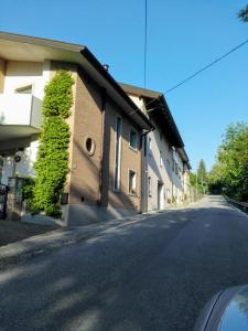 eine leere Straße neben einem Gebäude mit grüner Hecke in der Unterkunft Casa Via Castelmonte in Cividale del Friuli