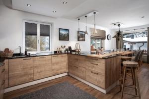 a kitchen with wooden cabinets and a large island at Chalet Schmitten 102 by Chalet Alp Lux in Zell am See