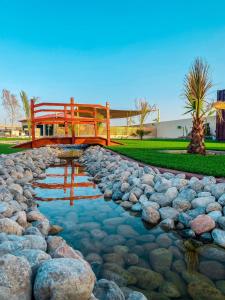 a bridge over a stream with rocks and a pond sidx sidx sidx at Seven Elements Resort in Ras al Khaimah