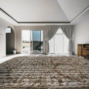 a bedroom with a large bed and a large window at Seven Elements Resort in Ras al Khaimah