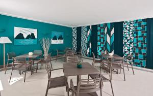 a dining room with tables and chairs and blue walls at Hotel Della Piccola Marina in Capri