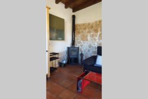 a living room with a chair and a stove at Casa Ambiente Rural: En plena Ribera del Duero in Mélida