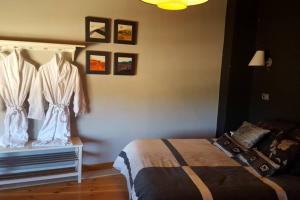 1 dormitorio con 1 cama y algunas fotos en la pared en Casa Ambiente Rural: En plena Ribera del Duero, en Mélida