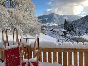 a fence covered in snow with mountains in the background at Chalet Schmitten 102 by Chalet Alp Lux - Opposite ski lift in Zell am See