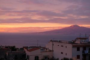 a view of a mountain and the ocean at sunset at La Casa nel Cortile in Vico Equense
