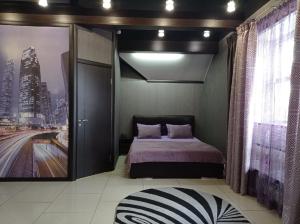 a bedroom with a bed and a picture of a city at Ost-roff Hotel in Izhevsk