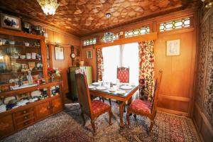 comedor con mesa, sillas y ventana en The Shelter Group of Houseboats & Tour organiser, en Srinagar