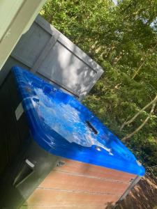 um barco azul sentado fora de uma casa em Jax Retreat hot tub and free golf em Felton
