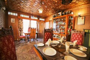 シュリーナガルにあるThe Shelter Group of Houseboats & Tour organiserのダイニングルーム(テーブル、椅子付)、ダイニングルームが備わります。