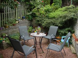 un grupo de sillas y una mesa en un jardín en Sunny House with views to Edinburgh Skyline en Edimburgo