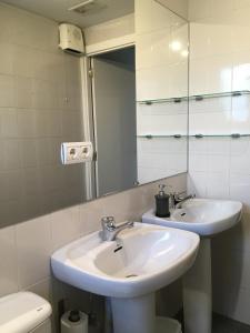 a bathroom with a sink and a mirror and a toilet at Zarautz Hostel in Zarautz