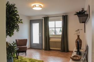 a living room with a chair and a window at Haus Emmerich in Gaienhofen