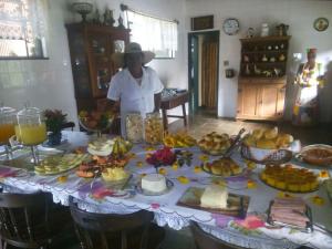 a woman standing in front of a table full of food at Hotel Fazenda Pirapetinga 