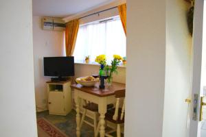 a room with a table with a television and a window at Romantic Flint Cottage on the Suffolk Coast in Saxmundham
