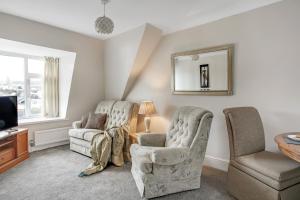 a living room with two chairs and a television at The Chesterfield Guest House, Torquay in Torquay