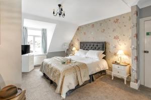 een slaapkamer met een groot bed en een televisie bij The Chesterfield Guest House, Torquay in Torquay