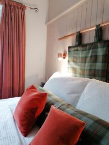 um quarto com duas almofadas vermelhas numa cama em Blas Rooms em Dunvegan