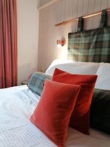 two red pillows sitting on top of a bed at Blas Rooms in Dunvegan