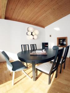 uma sala de jantar com uma mesa preta e cadeiras em The Seefeld Retreat - Central Family Friendly Chalet - Mountain Views em Seefeld in Tirol