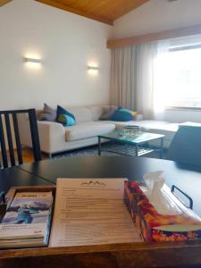 a living room with a table with books on it at The Seefeld Retreat - Central Family Friendly Chalet - Mountain Views in Seefeld in Tirol