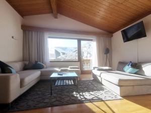 a living room with a couch and a table at The Seefeld Retreat - Central Family Friendly Chalet - Mountain Views in Seefeld in Tirol