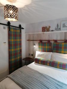 1 dormitorio con cama y lámpara de araña en Blas Rooms en Dunvegan