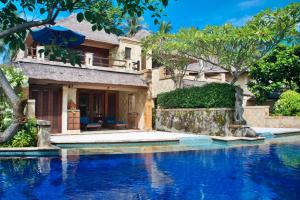 a house with a swimming pool in front of a house at Pool Villa Merumatta Senggigi in Senggigi