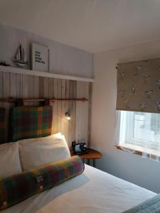 ein Schlafzimmer mit einem Bett und ein Fenster mit einem Blindfenster in der Unterkunft Blas Rooms in Dunvegan