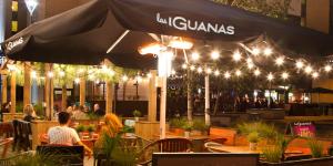 a restaurant with people sitting at tables under an umbrella at Apartment in Central MK - Bed Choice of 1 Super-king Or 2 Singles and also 2 Sofa Beds - Free Parking and Smart TV - Contractors, Relocation, Business Travellers in Milton Keynes