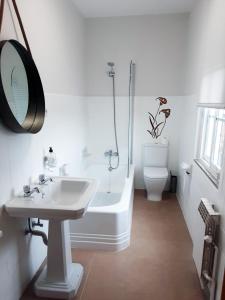 a bathroom with a sink and a tub and a toilet at Pensión Casa do Gallo Sarria in Sarria