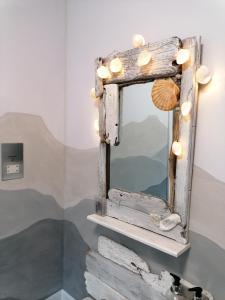 a mirror with seashells and lights on a shelf at Blas Rooms in Dunvegan