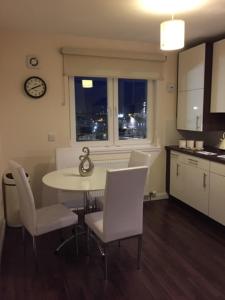 a kitchen with a table, chairs and a refrigerator at AB11 Apartments - Portland Street in Aberdeen