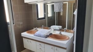 a bathroom with two sinks and a mirror at Appartement tout confort au milieu de la Margeride in Châteauneuf-de-Randon +17 photos