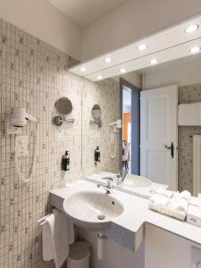 y baño con lavabo y espejo. en Hôtel de la Rose, en Fribourg